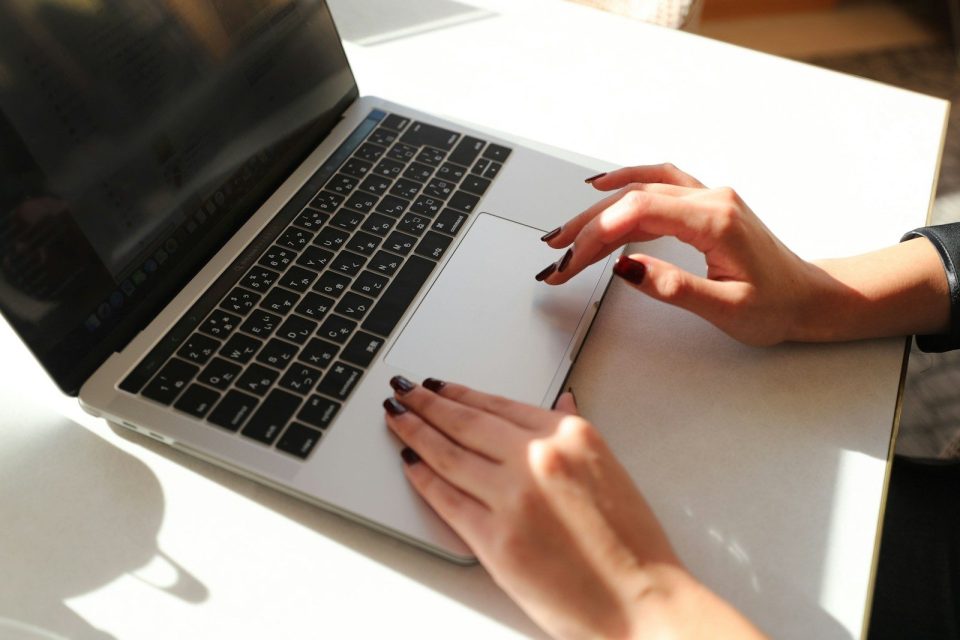 A woman sitting at a table using a laptop computer