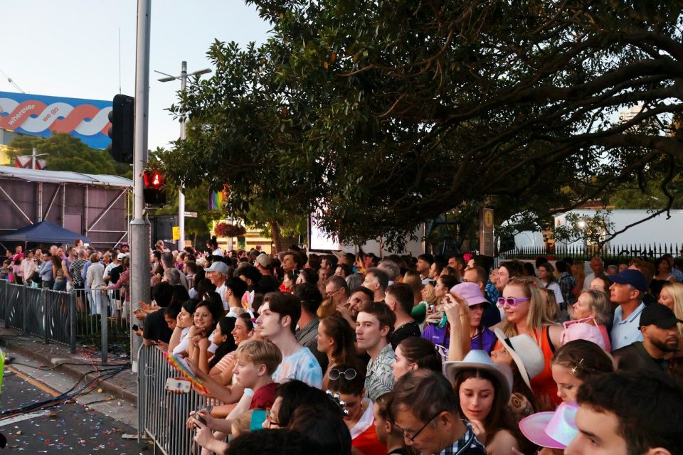 Crowd of people watching an outdoor event at dusk